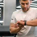 Man checking smartwatch in a gym.